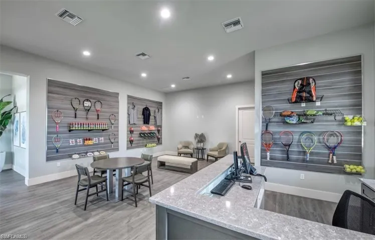 Kitchen with light stone countertops and hardwood / wood-style floors
