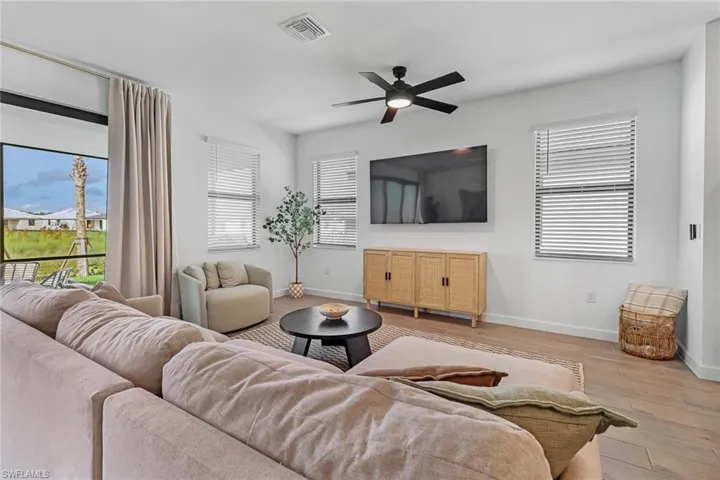 Living room with ceiling fan and light hardwood / wood-style floors