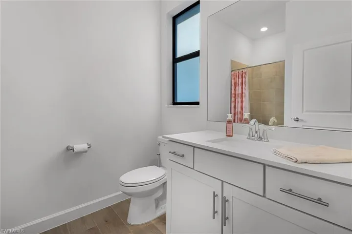 Bathroom with wood-type flooring, toilet, and vanity