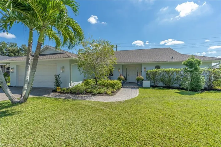 Ranch-style home with a front yard and a garage