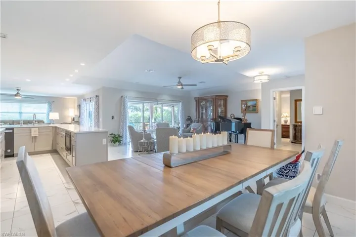 Dining room featuring ceiling fan with notable chandelier, a healthy amount of sunlight, and sink