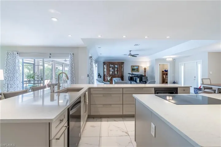Kitchen with ceiling fan, a spacious island, sink, and stainless steel dishwasher