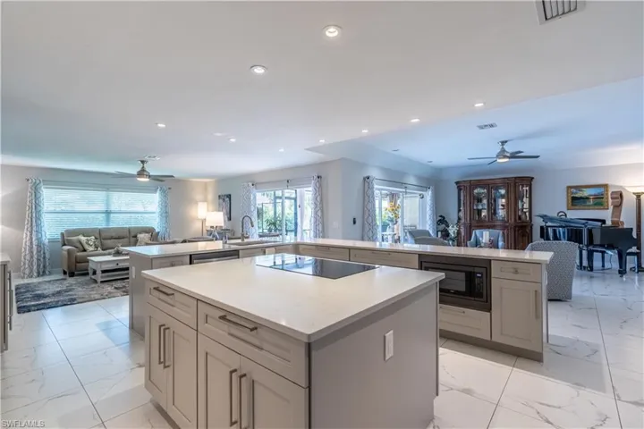 Kitchen featuring black appliances, kitchen peninsula, ceiling fan, and a wealth of natural light