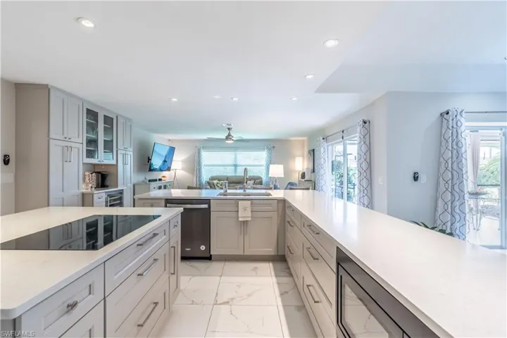 Kitchen featuring gray cabinetry, sink, ceiling fan, and stainless steel appliances
