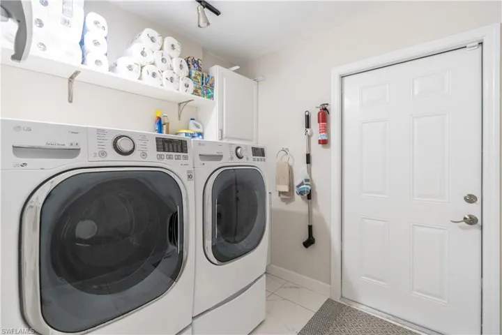 Washroom featuring washer and clothes dryer and cabinets