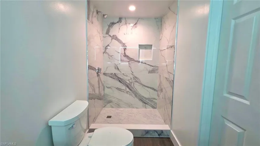 Bathroom with toilet and a marble finish shower