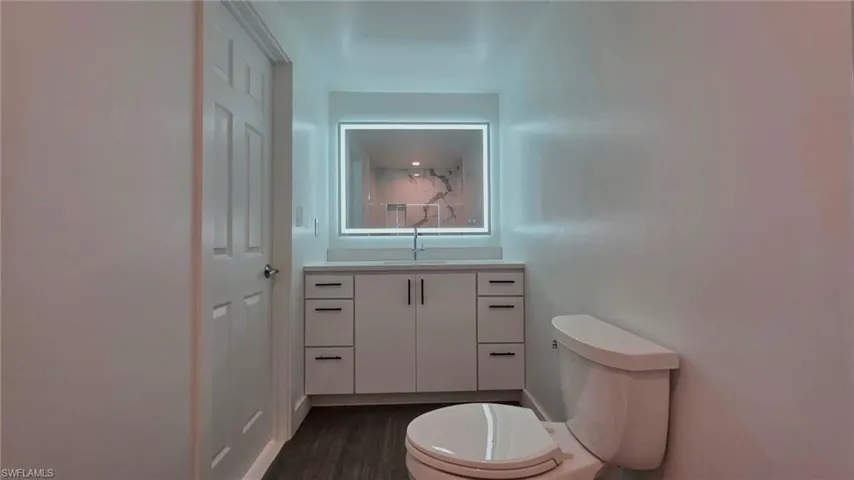 Half bath with vanity and dark wood finished floors