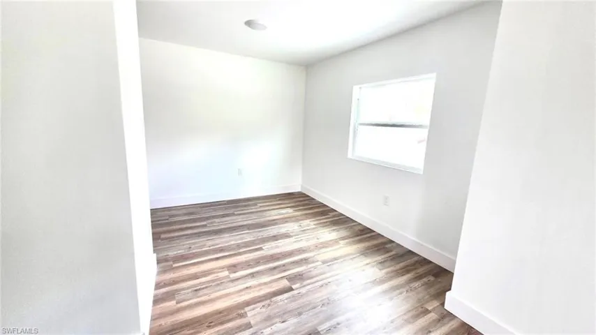 Empty room featuring wood finished floors and baseboards