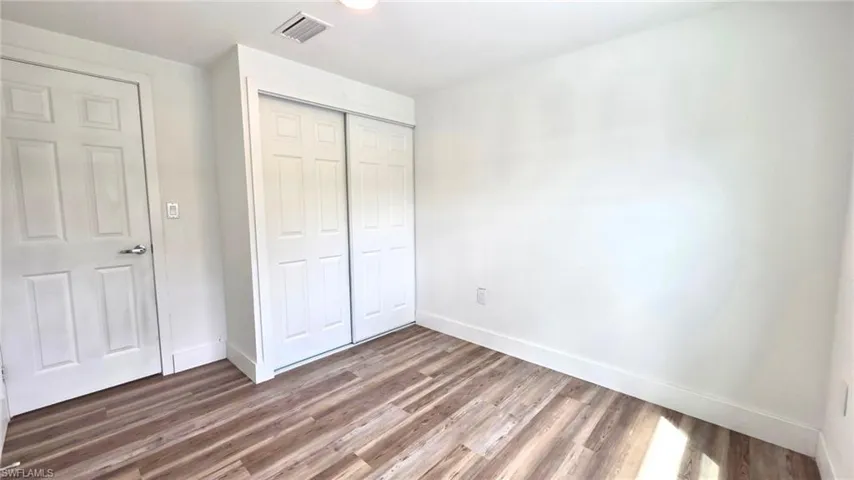 Unfurnished bedroom featuring a closet and wood finished floors