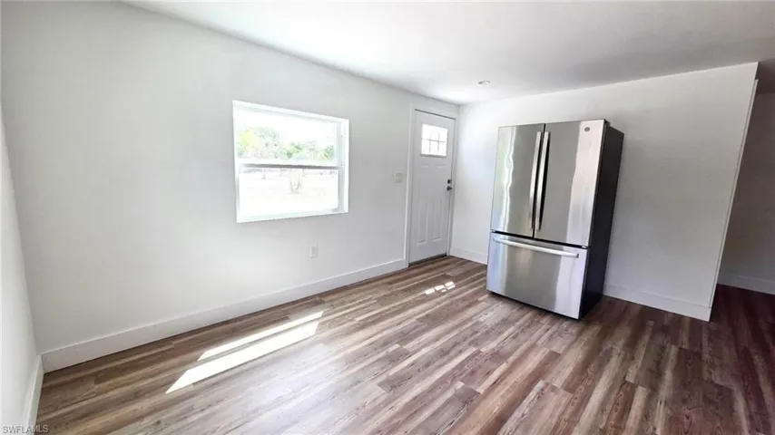 Kitchen featuring freestanding refrigerator and dark wood finished floors