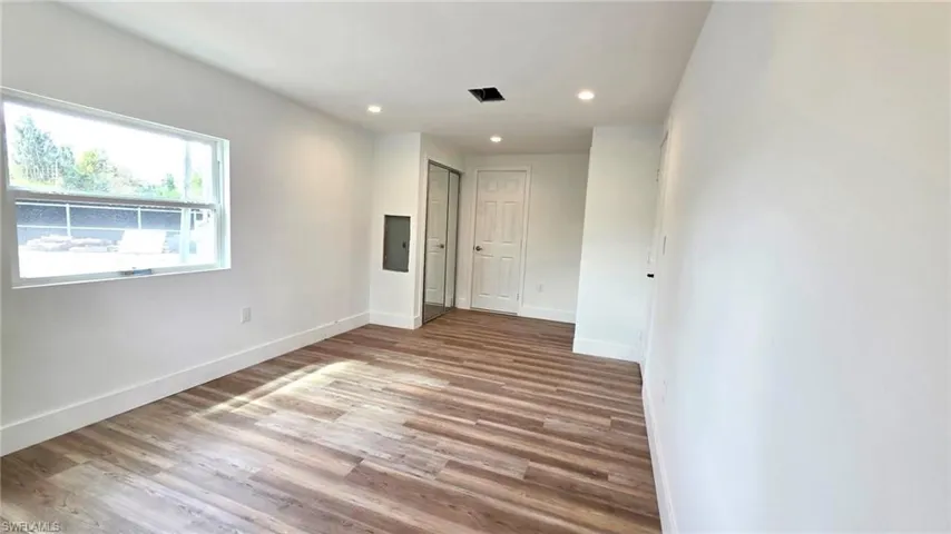 Spare room featuring light wood-type flooring, recessed lighting, and electric panel