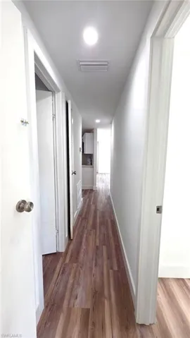 Hallway featuring dark wood finished floors and recessed lighting