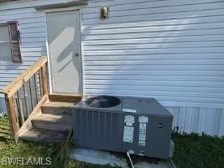 Exterior view of a central air condition unit and entry steps
