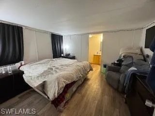 Bedroom featuring a textured ceiling, wood finished floors, and a decorative wall