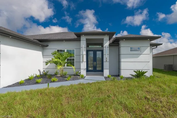 View of front of property with french doors and central AC unit