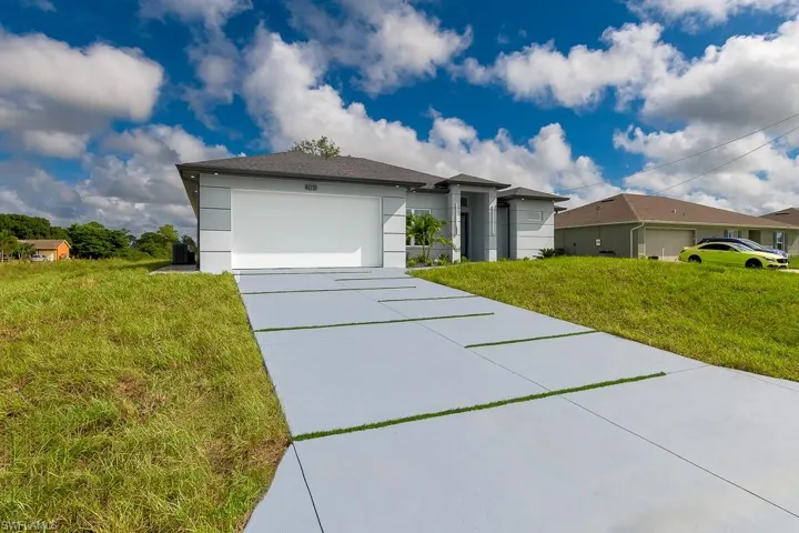 Single story home featuring a garage and a front lawn