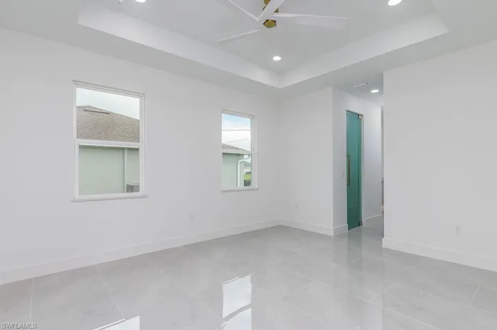 Spare room with ceiling fan and a tray ceiling