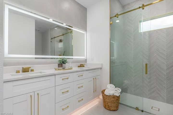 Bathroom with tile patterned floors, an enclosed shower, and vanity