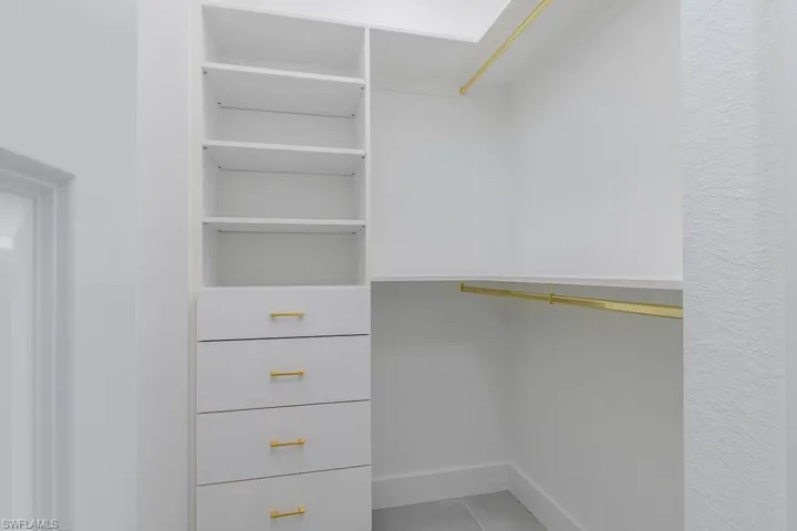 Walk in closet with light tile patterned floors
