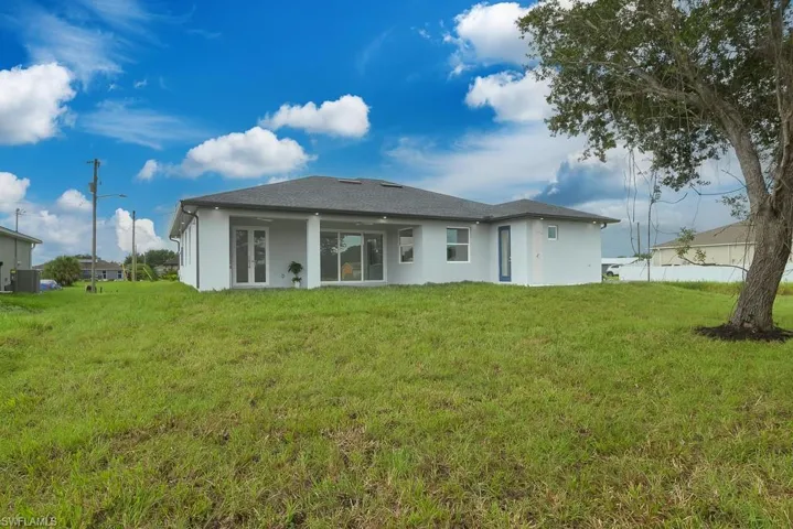 Rear view of house featuring a yard