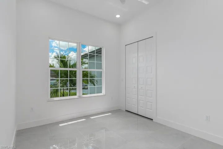 Unfurnished bedroom with ceiling fan and a closet