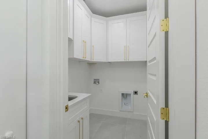 Laundry area featuring hookup for a washing machine, cabinets, and hookup for an electric dryer