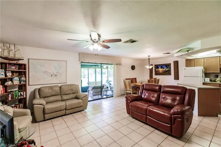 Living room featuring ceiling fan and light tile floors