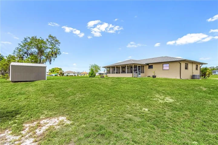 The property features an extensive back yard, a screened patio, and a storage shed
