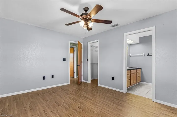 Primary Bedroom, with walk-on closet, wood plank style tile floor, blinds on windows