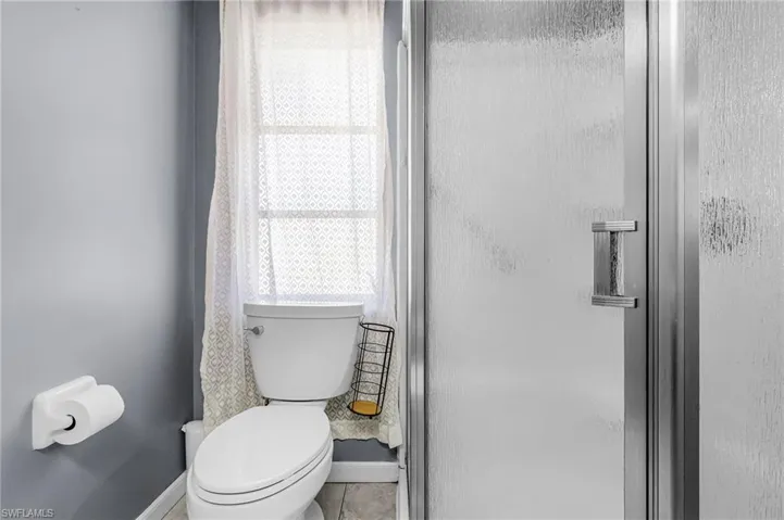 Primary Suite bathroom with large vanity and corner shower, pocket door to the bedroom, ceramic tile flooring