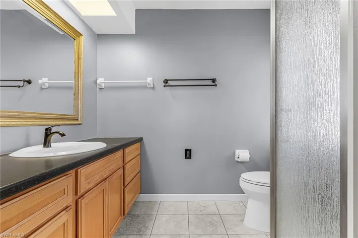 Primary Suite bathroom with large vanity and corner shower, pocket door to the bedroom, ceramic tile floor