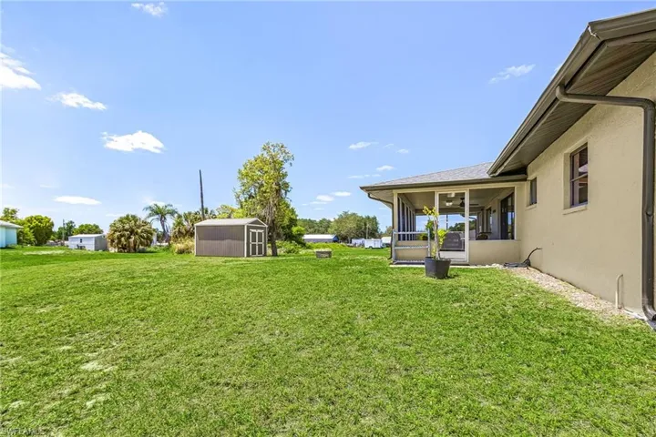 The property features an extensive back yard, a screened patio, and a storage shed