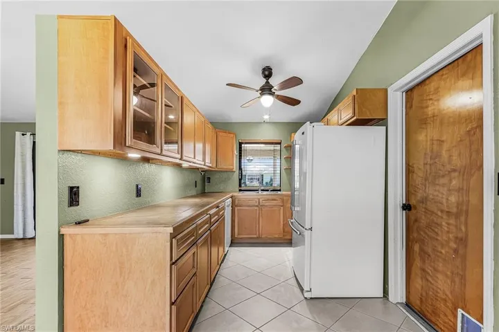 Wood cabinets, tile counter tops, dishwasher, range, microwave and refrigerator, reverse osmosis under sink for kitchen water,
