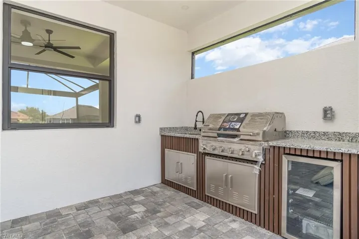 View of patio / terrace featuring area for grilling, wine cooler, a grill, and ceiling fan