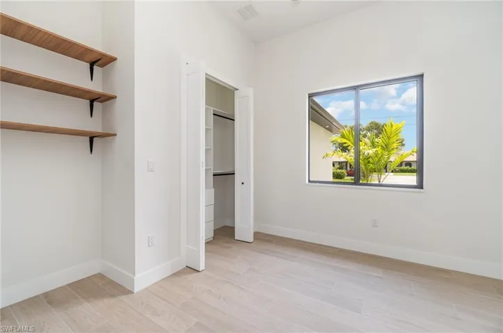 Unfurnished bedroom with light hardwood / wood-style flooring and a closet