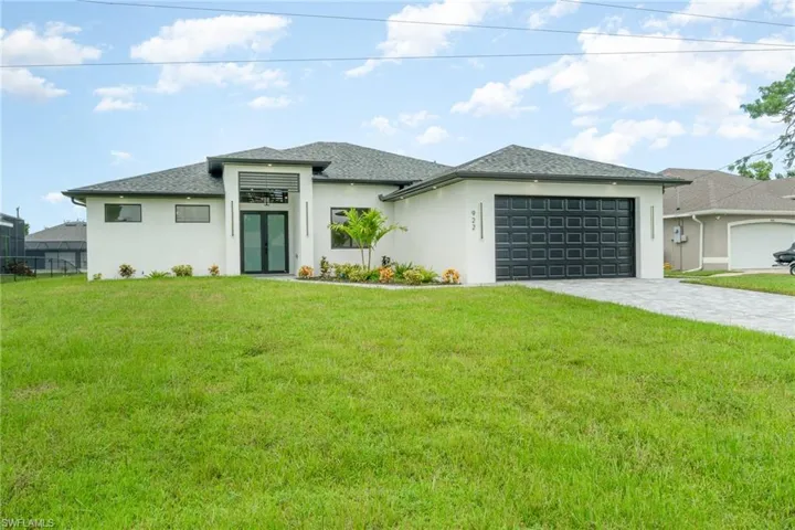 Prairie-style home with a garage and a front lawn