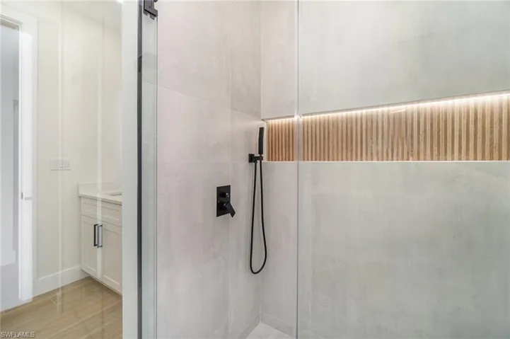 Bathroom featuring walk in shower, vanity, and tile patterned flooring