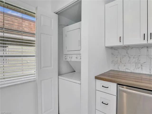 Laundry room with stacked washer and clothes dryer