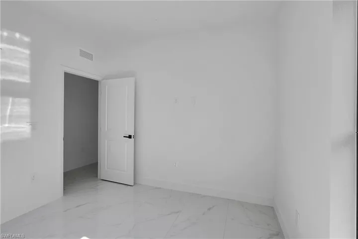 Spare room with light marble finish floors and baseboards