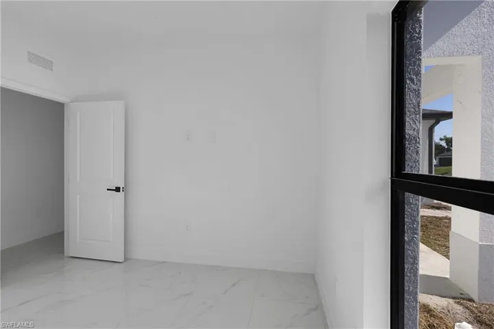 Unfurnished room featuring baseboards and light marble finish floors