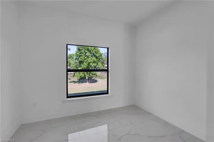 Spare room with baseboards and light marble finish floors