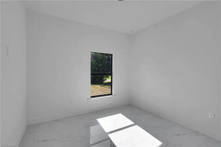 Spare room with light marble finish floors