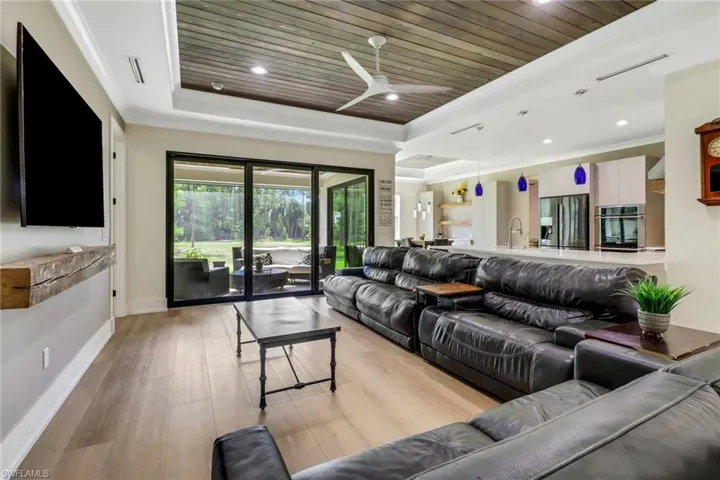 Living room featuring tongue and grove ceilings, crown molding, and beautiful natural light.