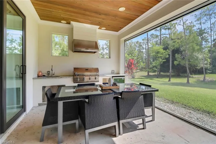 Screened lanai featuring outdoor kitchen, ceiling fan, tongue and grove ceilings, and electric screens and hurricane shutters.