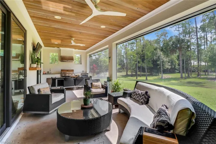 Screened lanai featuring outdoor kitchen, ceiling fan, tongue and grove ceilings, and electric screens and hurricane shutters.