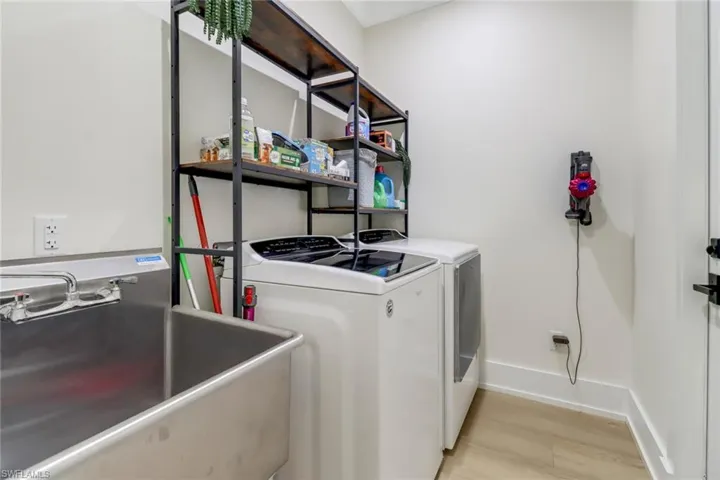 Laundry area featuring washing machine and dryer, and utility sink.