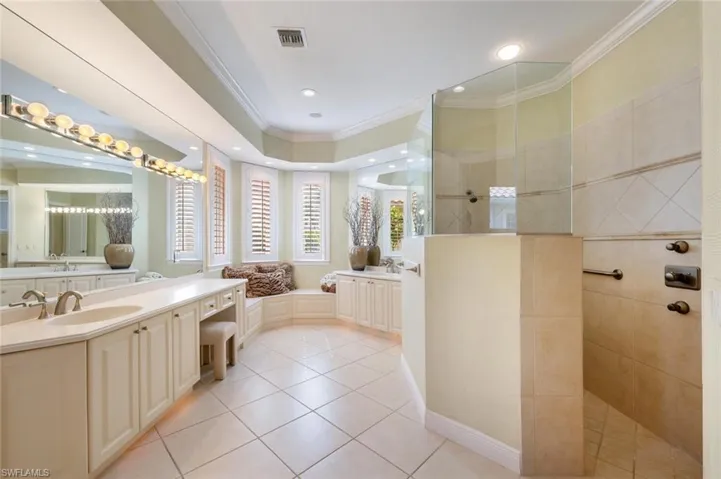 Dual sinks on separate sides with custom cabinets, customs mirrors and designer lighting