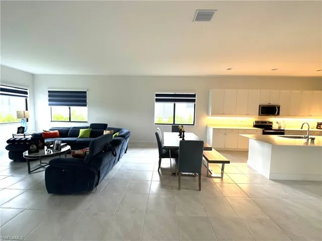 Tiled living room featuring sink and a wealth of natural light