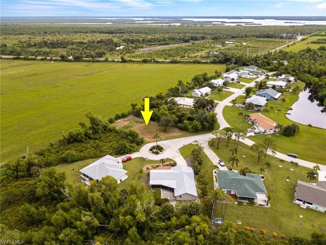 Aerial view of property and surrounding area with a large body of water and nearby suburban area