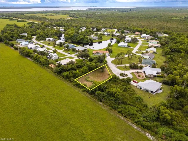 Aerial perspective of suburban area with a nearby body of water and property parcel outlined